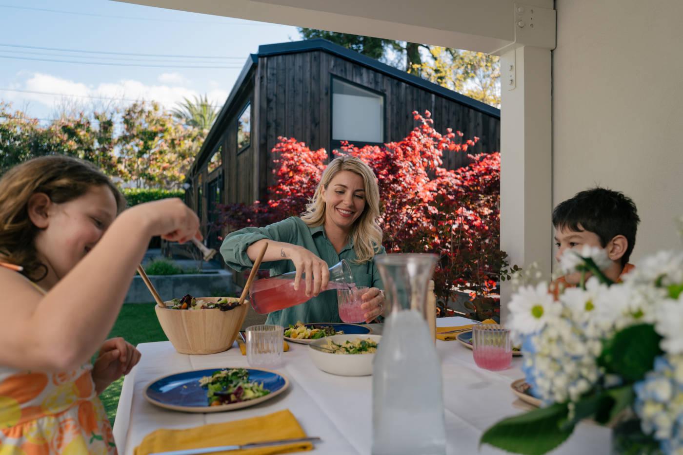 A family enjoying a nice dinner outside their Abodu amidst the nice warm weather.